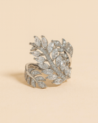 Silver leaf-shaped bracelet on a beige background