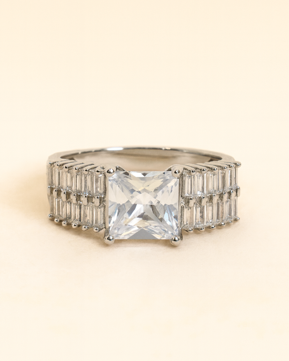 Ring with a large central gemstone and smaller stones on a beige background
