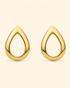 Gold teardrop earrings on a beige background
