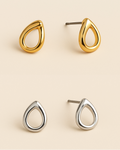 Gold and silver teardrop-shaped earrings on a beige background
