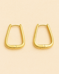 Gold hoop earrings on a beige background