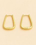 Gold hoop earrings on a beige background