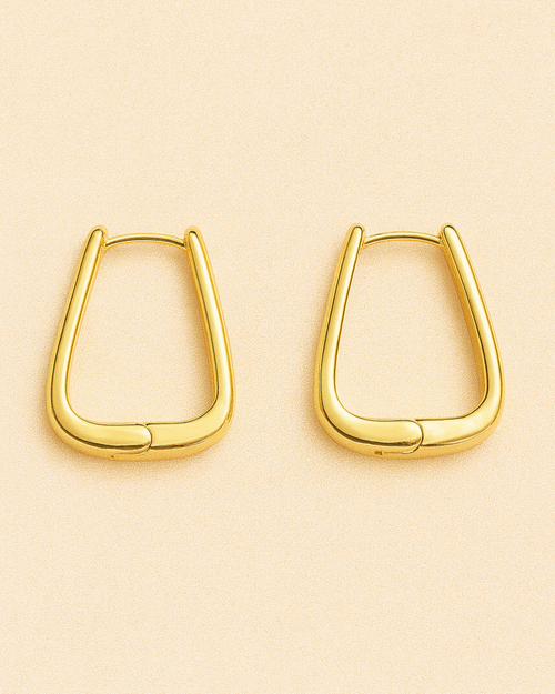 Gold hoop earrings on a beige background