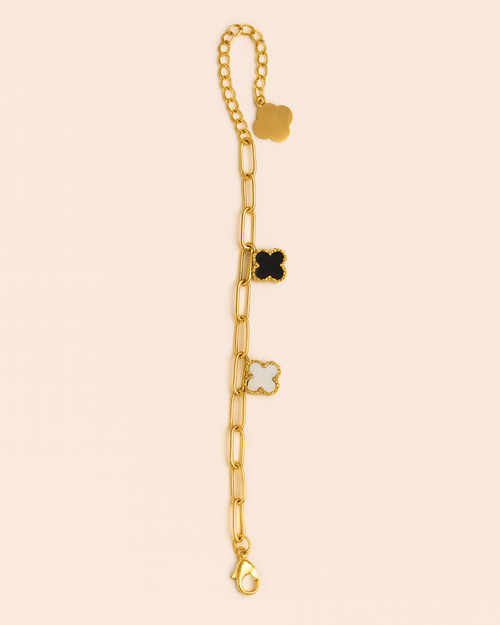 Gold bracelet with star-shaped charms on a beige background