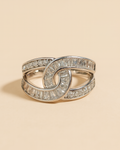 Artificial Anti-Tarnish silver ring with diamond accents on a beige background