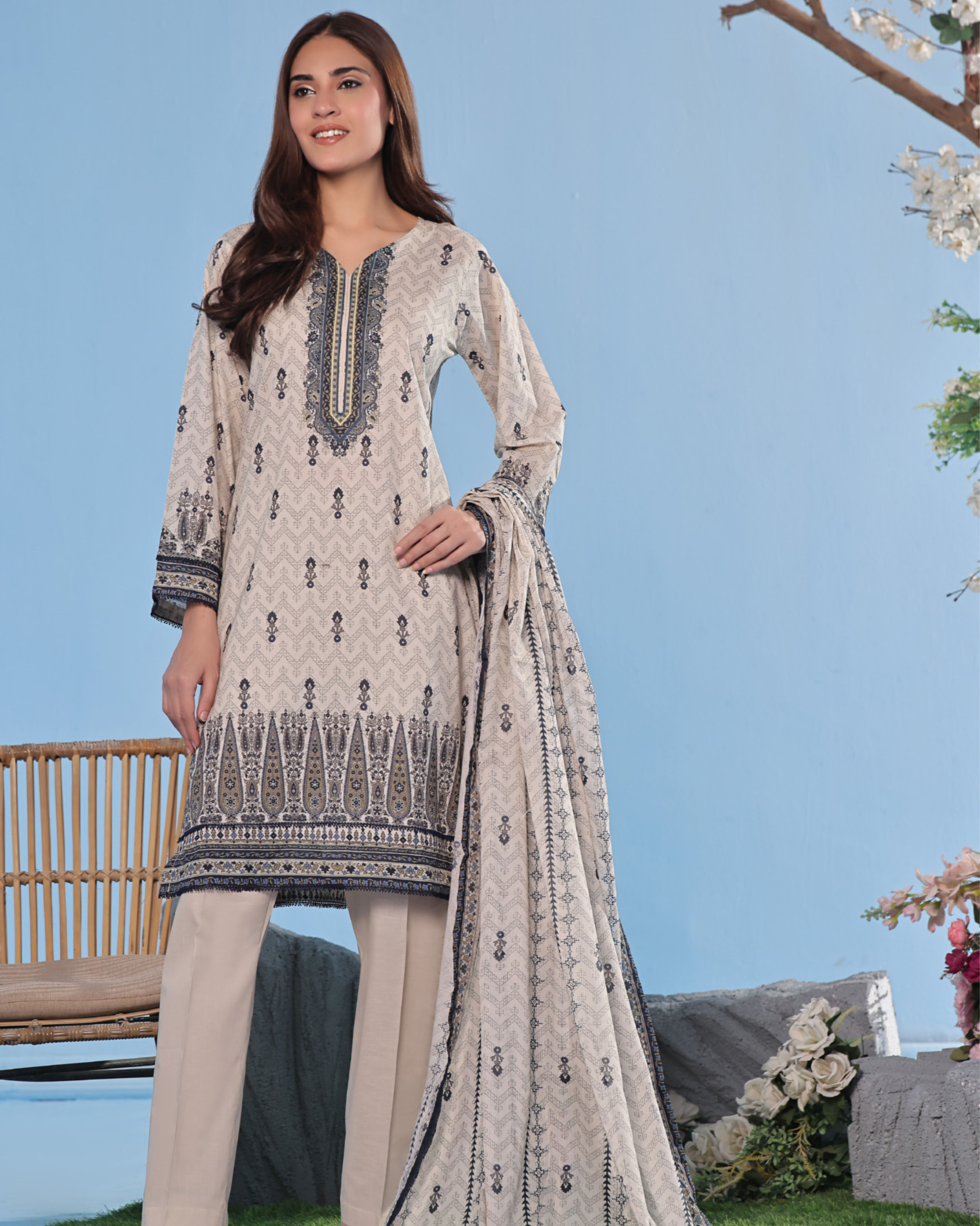 Woman wearing a beige embroidered outfit with a blue sky background